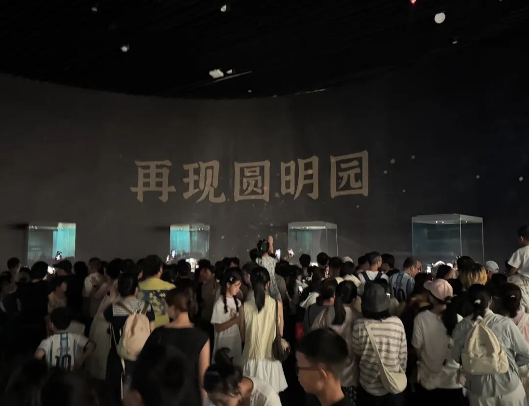圆明园兽首铜像展厅实景，观众隔着玻璃驻足凝视